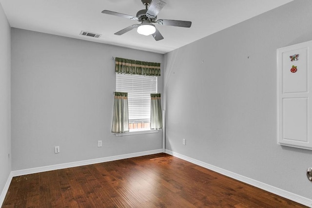 empty room with ceiling fan, wood finished floors, visible vents, and baseboards