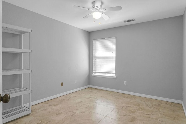 empty room with a ceiling fan, visible vents, and baseboards