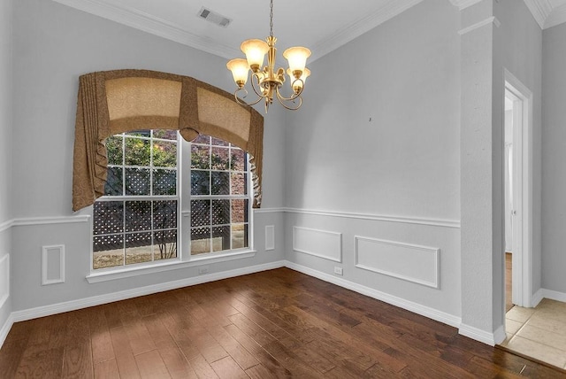 unfurnished dining area with a chandelier, hardwood / wood-style flooring, visible vents, ornamental molding, and wainscoting