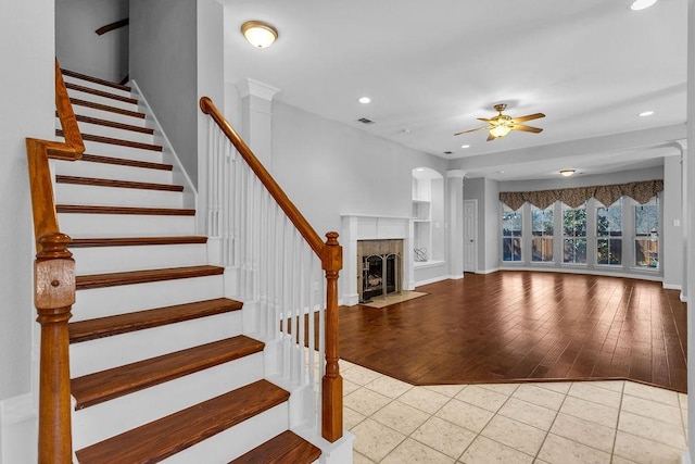 interior space with stairs, recessed lighting, a fireplace with flush hearth, and tile patterned floors