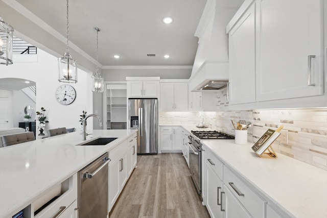 kitchen with stainless steel appliances, arched walkways, crown molding, and a sink