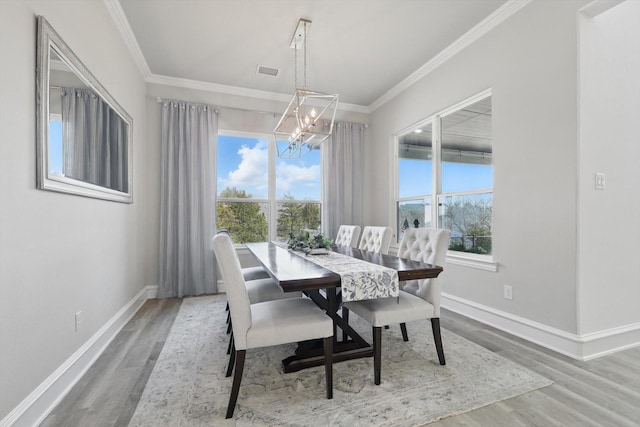 dining area featuring ornamental molding, baseboards, an inviting chandelier, and wood finished floors