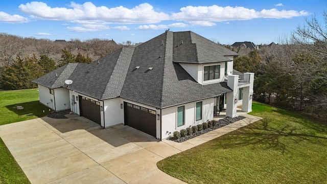 view of front facade with a garage, a shingled roof, concrete driveway, a front lawn, and stucco siding