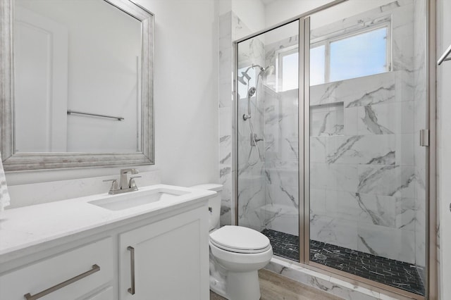 full bathroom with a marble finish shower, vanity, toilet, and wood finished floors