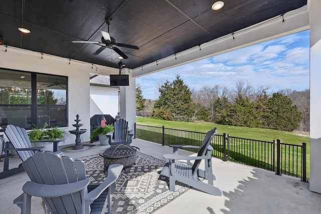 view of patio featuring an outdoor fire pit and a ceiling fan