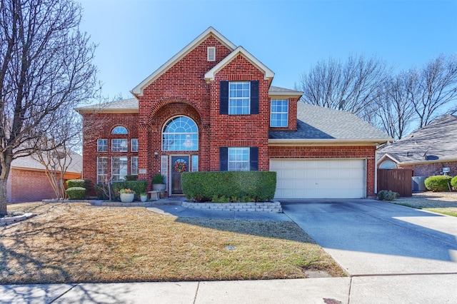 traditional-style home featuring brick siding, a shingled roof, concrete driveway, an attached garage, and a front lawn