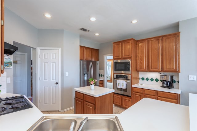 kitchen featuring stainless steel appliances, visible vents, light countertops, ventilation hood, and decorative backsplash