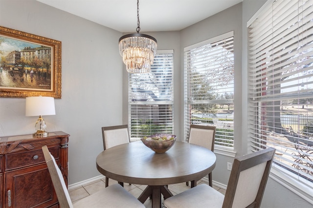 dining space featuring baseboards, light tile patterned flooring, and a notable chandelier