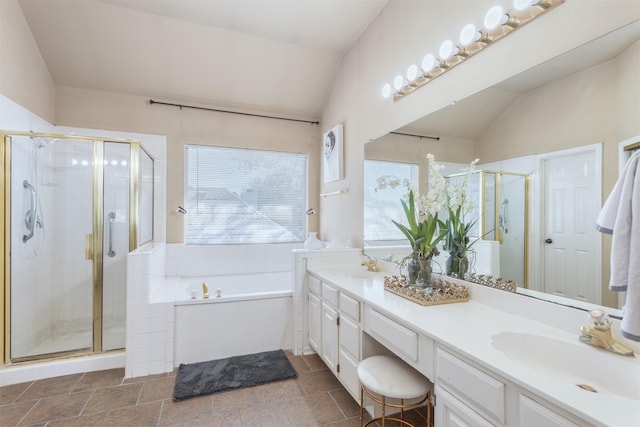 bathroom with lofted ceiling, a sink, a bath, double vanity, and a stall shower