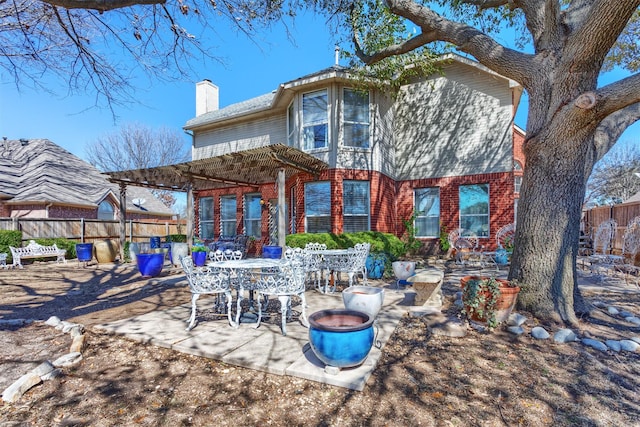 back of property featuring brick siding, fence, a pergola, a chimney, and a patio area