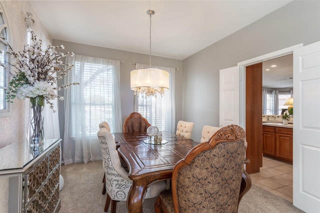 dining area with light tile patterned floors, light carpet, and a chandelier