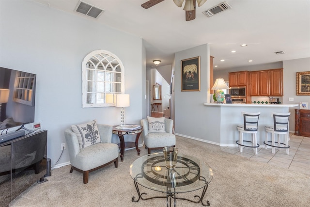 living area featuring recessed lighting, light tile patterned flooring, visible vents, and light colored carpet