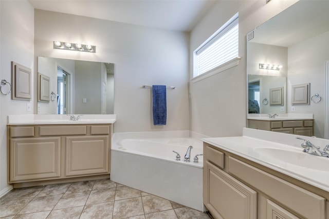 full bathroom with two vanities, a garden tub, a sink, and tile patterned floors