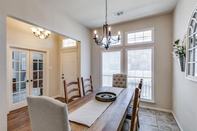 dining space with baseboards, french doors, a wealth of natural light, and a notable chandelier