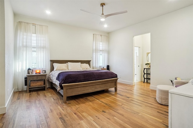 bedroom with light wood-type flooring, baseboards, and ceiling fan