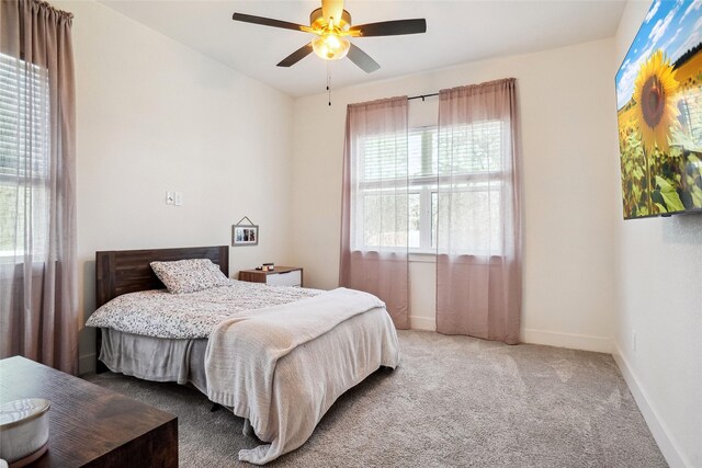 carpeted bedroom featuring baseboards and ceiling fan