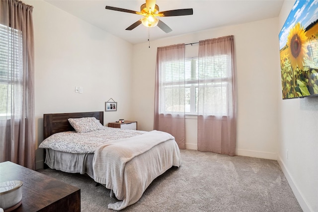 carpeted bedroom with baseboards and a ceiling fan