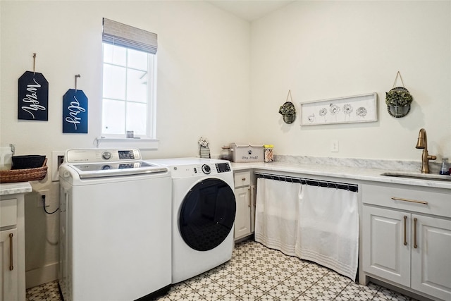 laundry area featuring a sink, cabinet space, light floors, and washing machine and clothes dryer