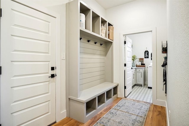 mudroom with washer / dryer and light wood-style flooring