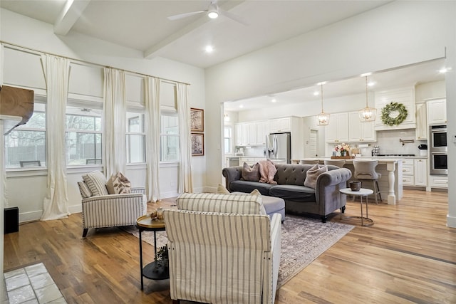 living area featuring beamed ceiling, baseboards, recessed lighting, a ceiling fan, and light wood-style flooring