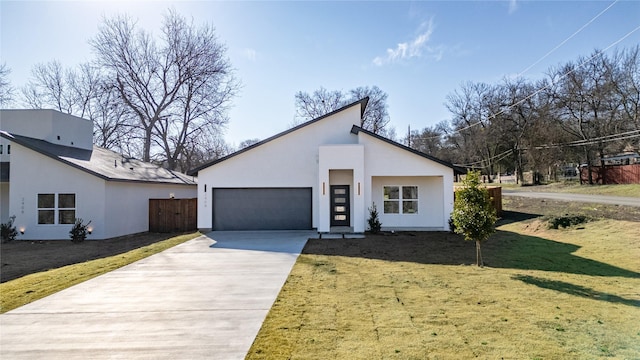 view of front of home featuring a garage, a front yard, driveway, and stucco siding