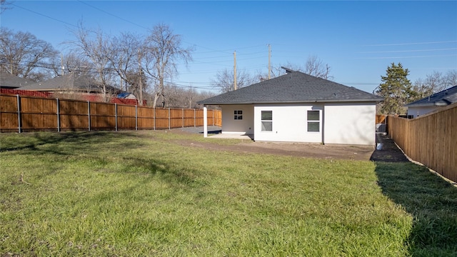 back of house with stucco siding, a fenced backyard, a patio area, and a yard