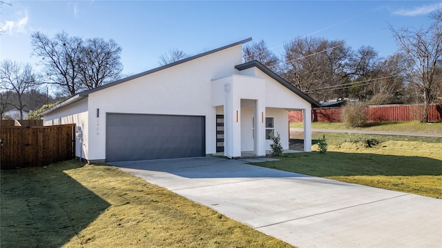 view of front of property featuring a garage, fence, a front lawn, and stucco siding