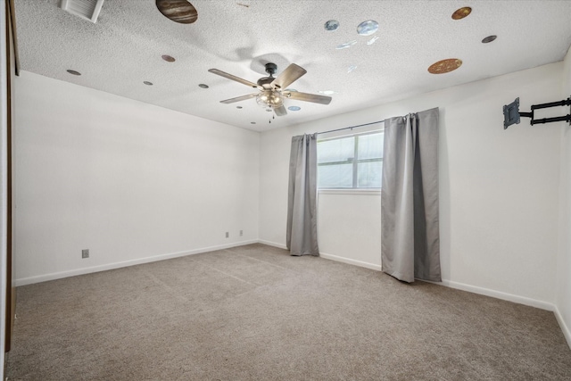 empty room with carpet, visible vents, and baseboards