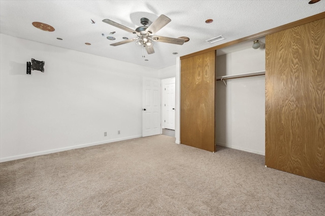 unfurnished bedroom featuring a closet, a textured ceiling, visible vents, and carpet flooring