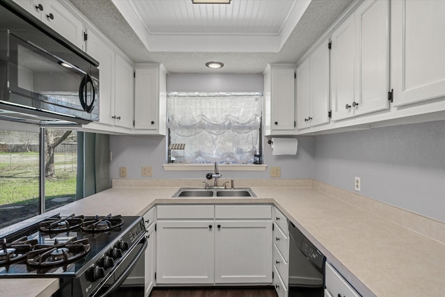 kitchen featuring black appliances, light countertops, a sink, and white cabinetry