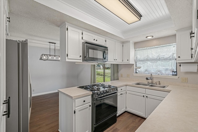 kitchen with a textured ceiling, dark wood-type flooring, a sink, white cabinets, and black appliances