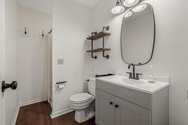 full bath with toilet, vanity, wood finished floors, a shower with curtain, and baseboards