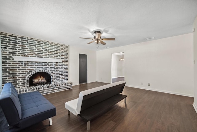 living area featuring a textured ceiling, a fireplace, and wood finished floors