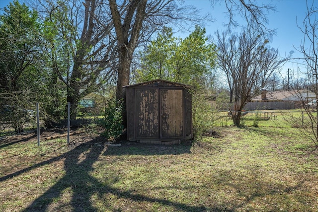 view of yard featuring an outdoor structure, fence, and a storage unit