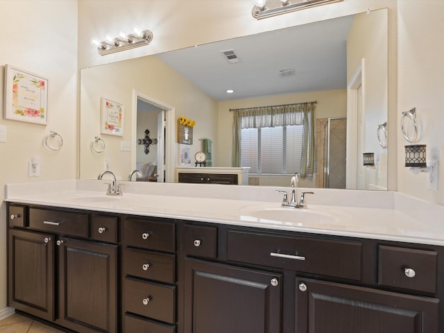 full bathroom with double vanity, a sink, visible vents, and a shower stall