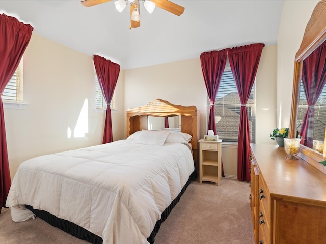 bedroom with a ceiling fan and light colored carpet