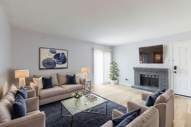 living room with a fireplace, wood finished floors, and baseboards