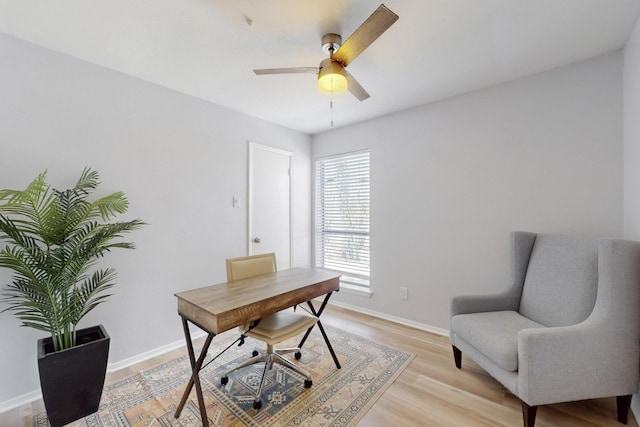 home office featuring light wood-style floors, baseboards, and a ceiling fan