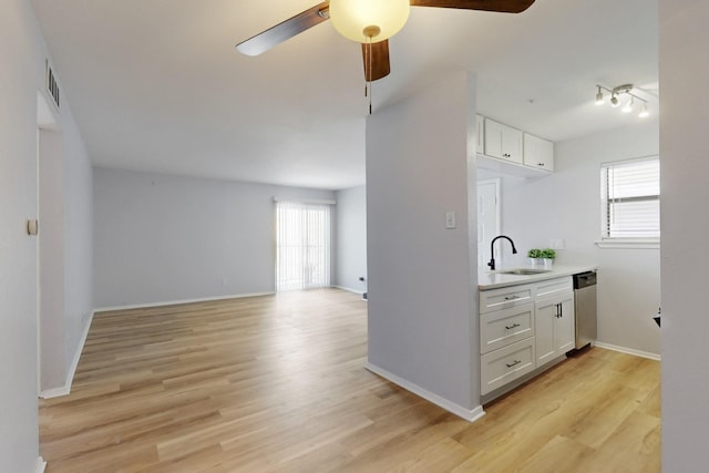 kitchen with plenty of natural light, white cabinets, a sink, and dishwasher