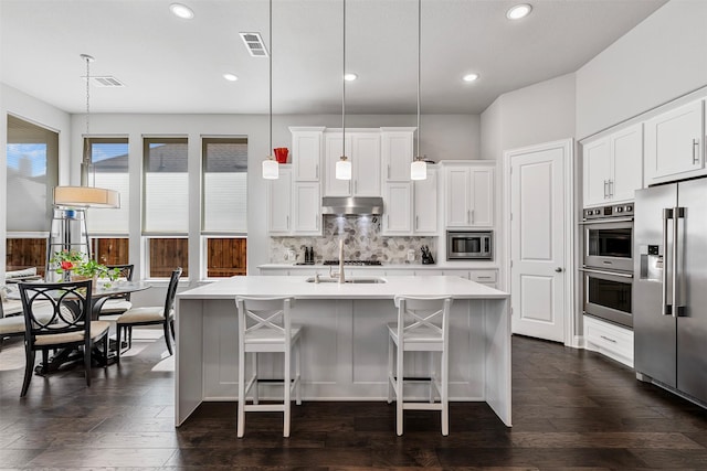 kitchen featuring under cabinet range hood, visible vents, stainless steel appliances, and light countertops