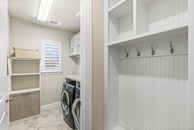 laundry area featuring separate washer and dryer, visible vents, baseboards, marble finish floor, and cabinet space