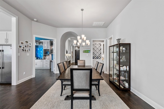 dining area featuring a notable chandelier, visible vents, arched walkways, and dark wood finished floors