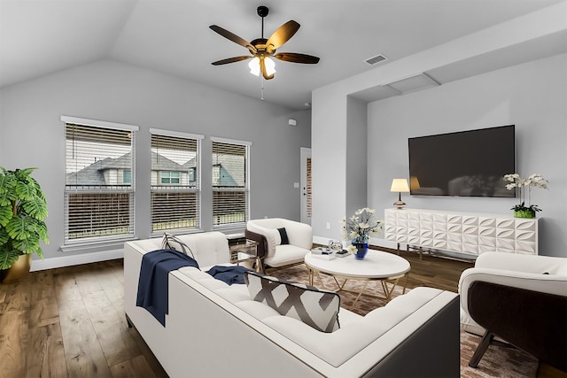 living area featuring a ceiling fan, wood finished floors, visible vents, baseboards, and lofted ceiling