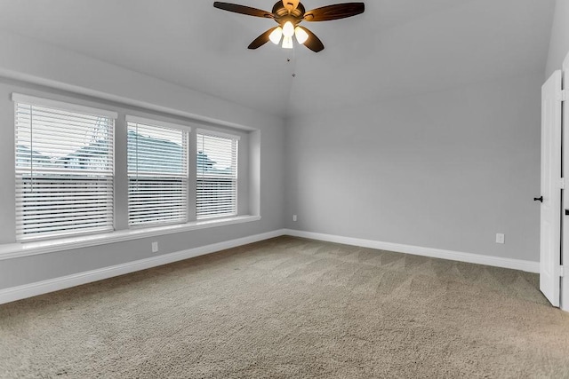 empty room with lofted ceiling, baseboards, carpet floors, and ceiling fan