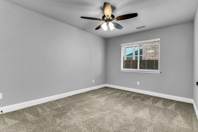 unfurnished room with dark colored carpet, visible vents, baseboards, and a ceiling fan