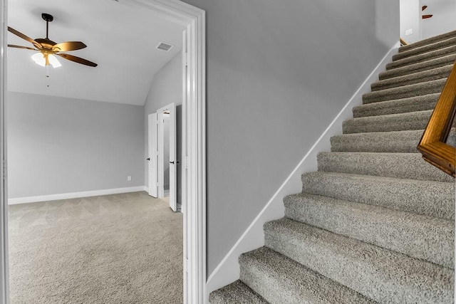 stairway with baseboards, visible vents, ceiling fan, vaulted ceiling, and carpet flooring