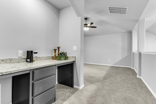 bar featuring baseboards, light colored carpet, visible vents, and ceiling fan