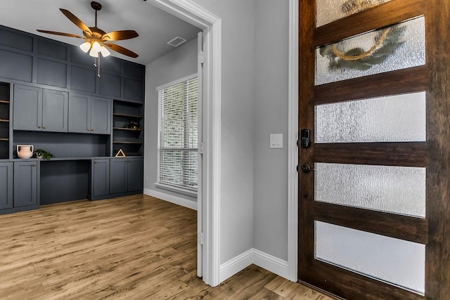 foyer featuring visible vents, baseboards, light wood-style floors, and ceiling fan