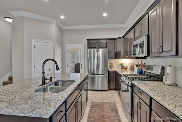 kitchen featuring appliances with stainless steel finishes, crown molding, a sink, and decorative backsplash