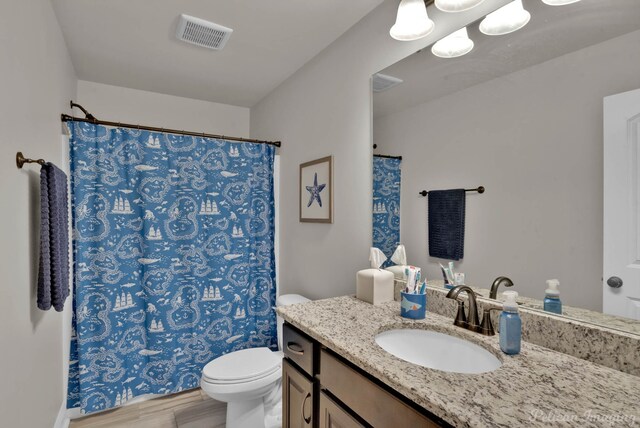 full bath featuring toilet, wood finished floors, vanity, visible vents, and a shower with curtain